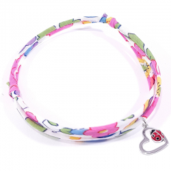 bracelet tissu liberty fleur de fuchsia avec pendentif coccinelle posée sur cœur en argent.