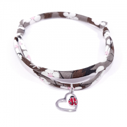 bracelet tissu liberty marron avec pendentif coccinelle posée sur cœur en argent.