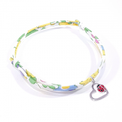 bracelet tissu liberty fleur de mimosa avec pendentif coccinelle posée sur cœur en argent.