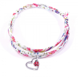 bracelet tissu liberty fleurs multicolores avec pendentif coccinelle posée sur cœur en argent.
