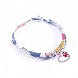 bracelet tissu liberty fleurs avec pendentif coccinelle posée sur cœur en argent.
