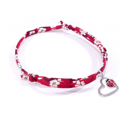 bracelet tissu liberty rouge avec pendentif coccinelle posée sur cœur en argent.