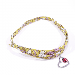 bracelet tissu liberty rouge avec pendentif coccinelle posée sur cœur en argent.