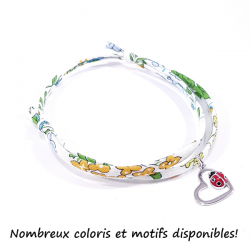 bracelet tissu liberty fleur de capucine avec pendentif coccinelle posée sur cœur en argent.
