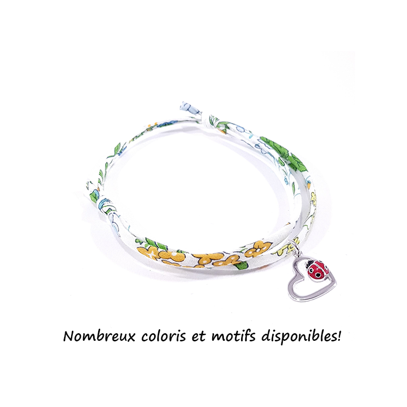 bracelet tissu liberty fleur de capucine avec pendentif coccinelle posée sur cœur en argent.