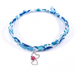 bracelet en tissu liberty bleu clair avec pendentif coccinelle posée sur deux cœurs