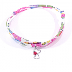 bracelet en tissu liberty fleur de fuchsia avec pendentif coccinelle posée sur deux cœurs