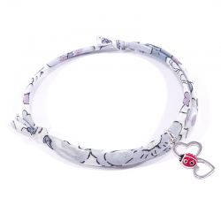 bracelet en tissu liberty gris avec pendentif coccinelle posée sur deux cœurs en argent