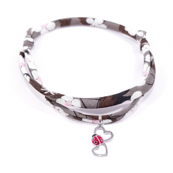 bracelet en tissu liberty marron gris avec pendentif coccinelle posée sur deux cœurs