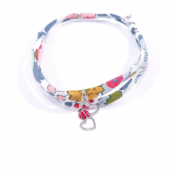 bracelet en tissu liberty fleurs avec pendentif coccinelle posée sur deux cœurs