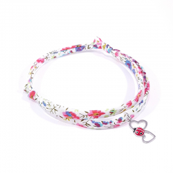 bracelet en tissu liberty fleurs multicolores avec pendentif coccinelle posée sur deux cœurs en argent
