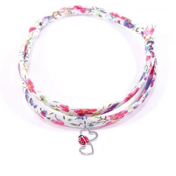 bracelet en tissu liberty fleurs multicolores avec pendentif coccinelle posée sur deux cœurs