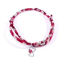 bracelet en tissu liberty rouge avec pendentif coccinelle posée sur deux cœurs