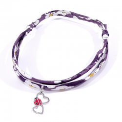 bracelet en tissu liberty violet avec pendentif coccinelle posée sur deux cœurs